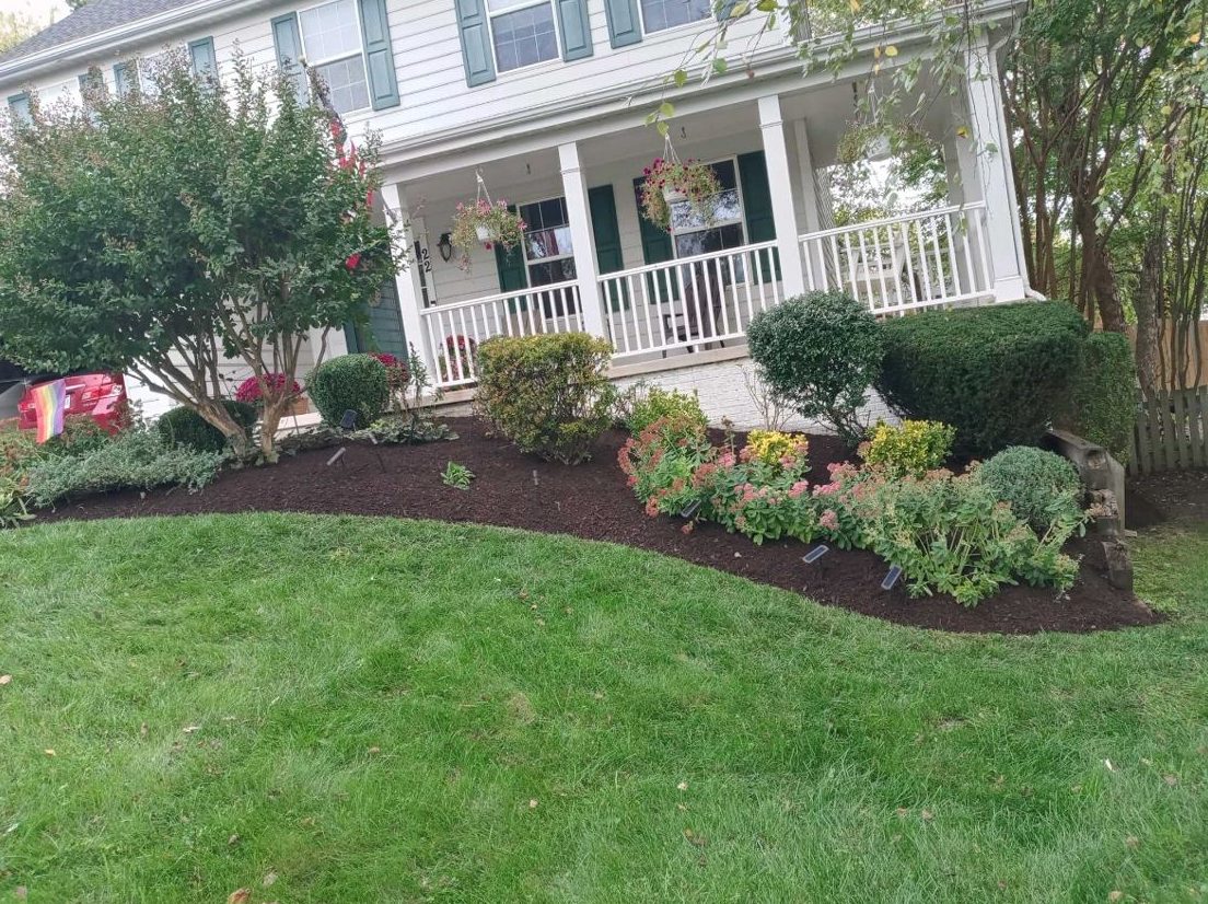 Curved mulched bed in front of a porch