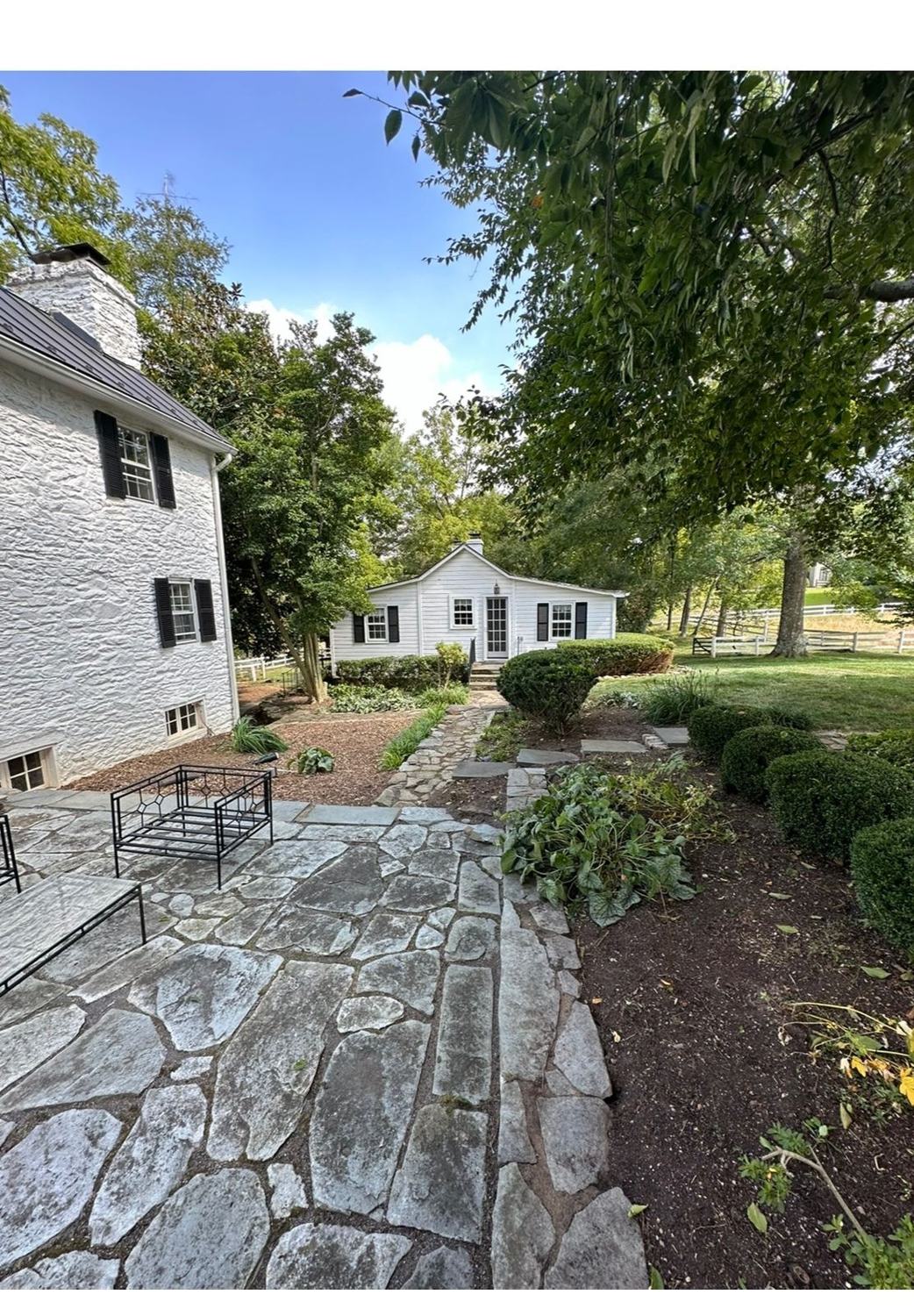 Flagstone patio with seating beside garden beds