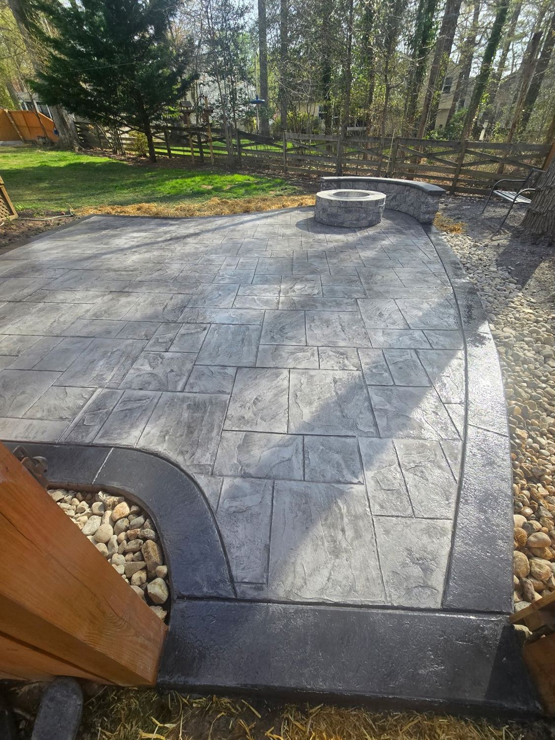 Stamped concrete patio with a built-in fire pit and curved seat wall